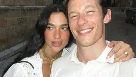 Dua Lipa showing off her finger tattoo with Callum Turner