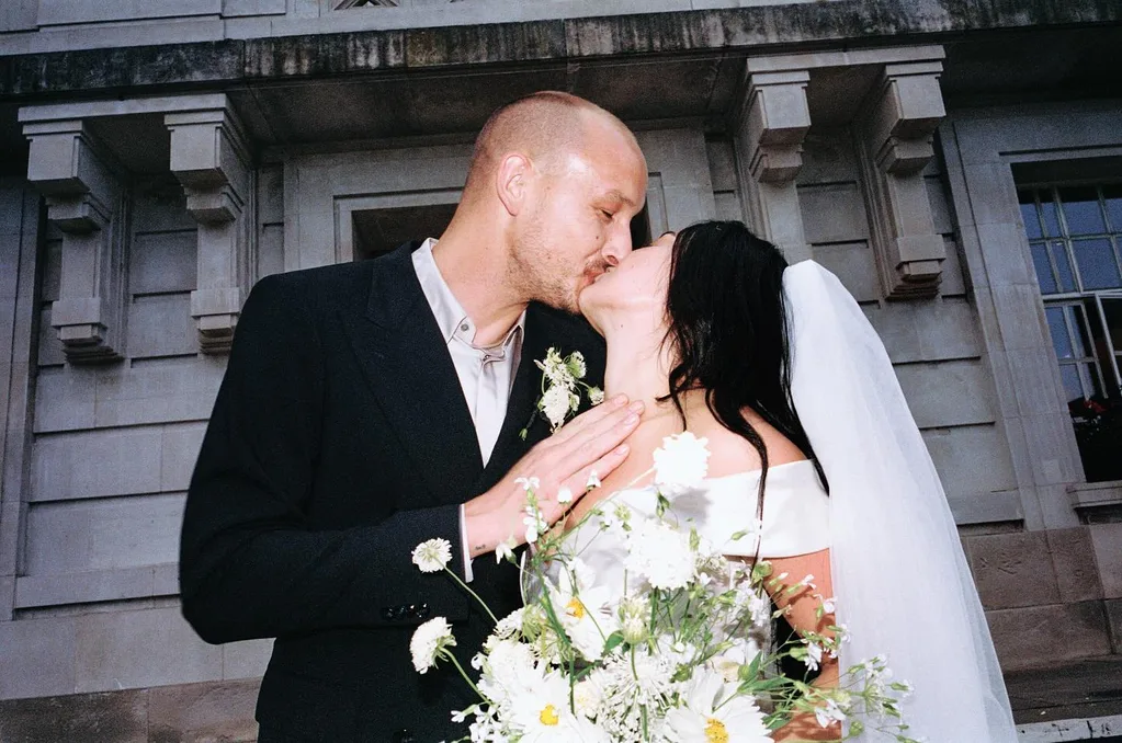 Charli XCX and her husband George kissing outside the courthouse on their wedding day