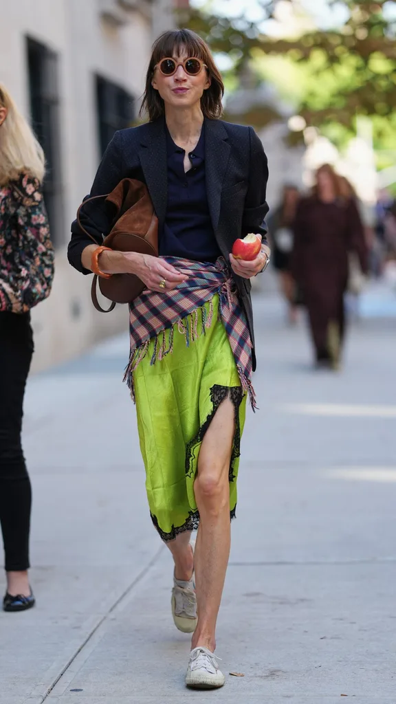 Guest at NYFW wears acid green slip skirt with chequered scarf tied around the waist