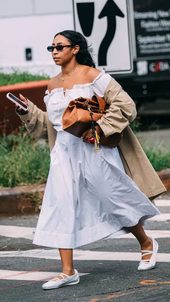 Guest at NYFW wears summer dress with sneakerinas