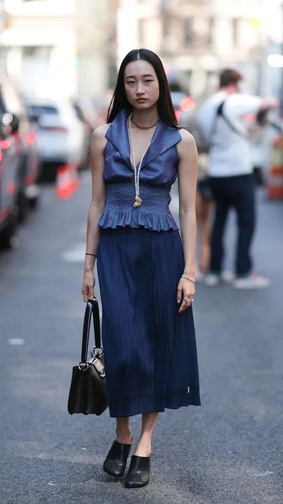 Guest at NYFW wears navy midi skirt
