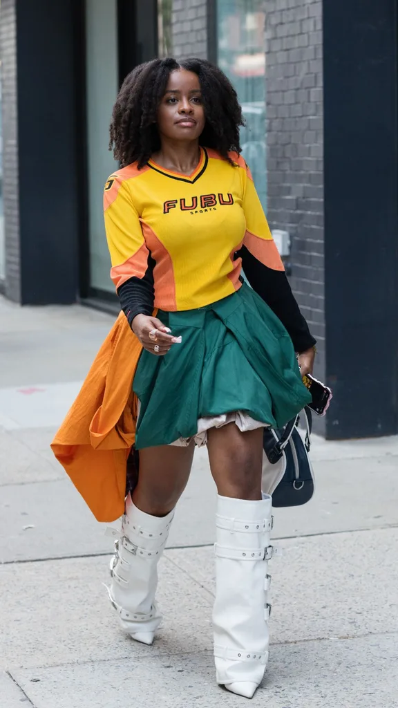 Guest at nyfw wears yellow sports shirt with white boots