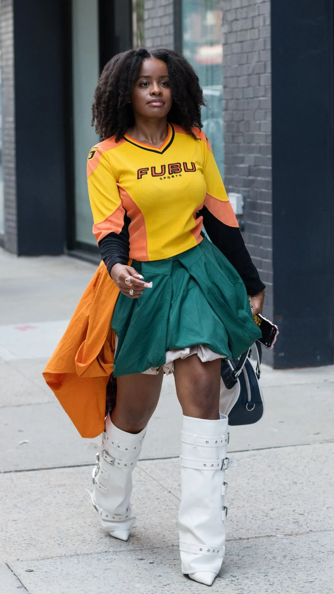Guest at nyfw wears yellow sports shirt with white boots 