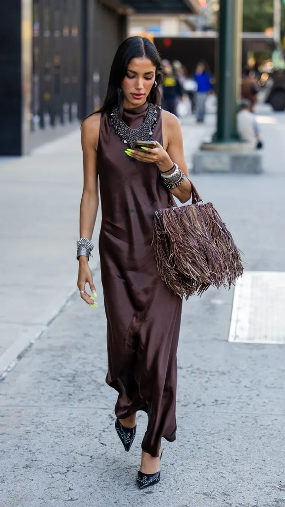 Guest at nyfw wears brown silk maxi dress
