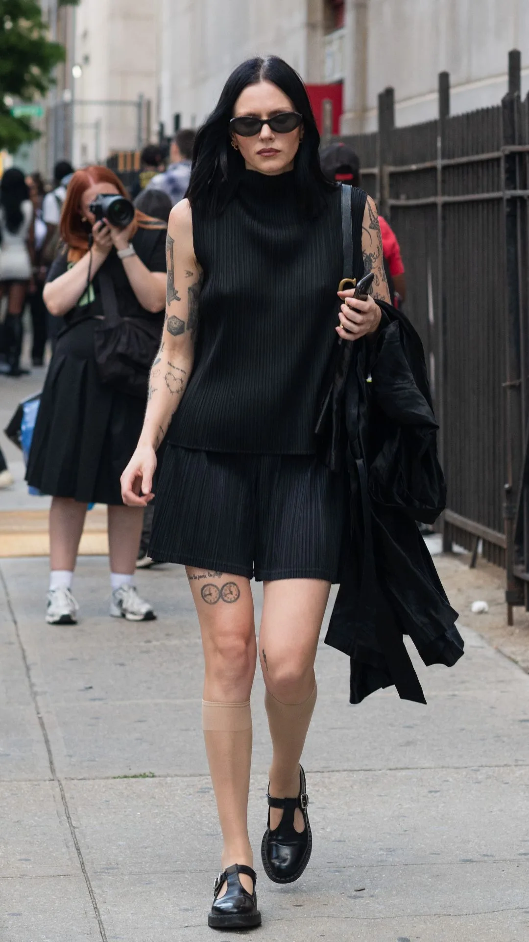 Guest at NYFW wears black shift dress with loafers 
