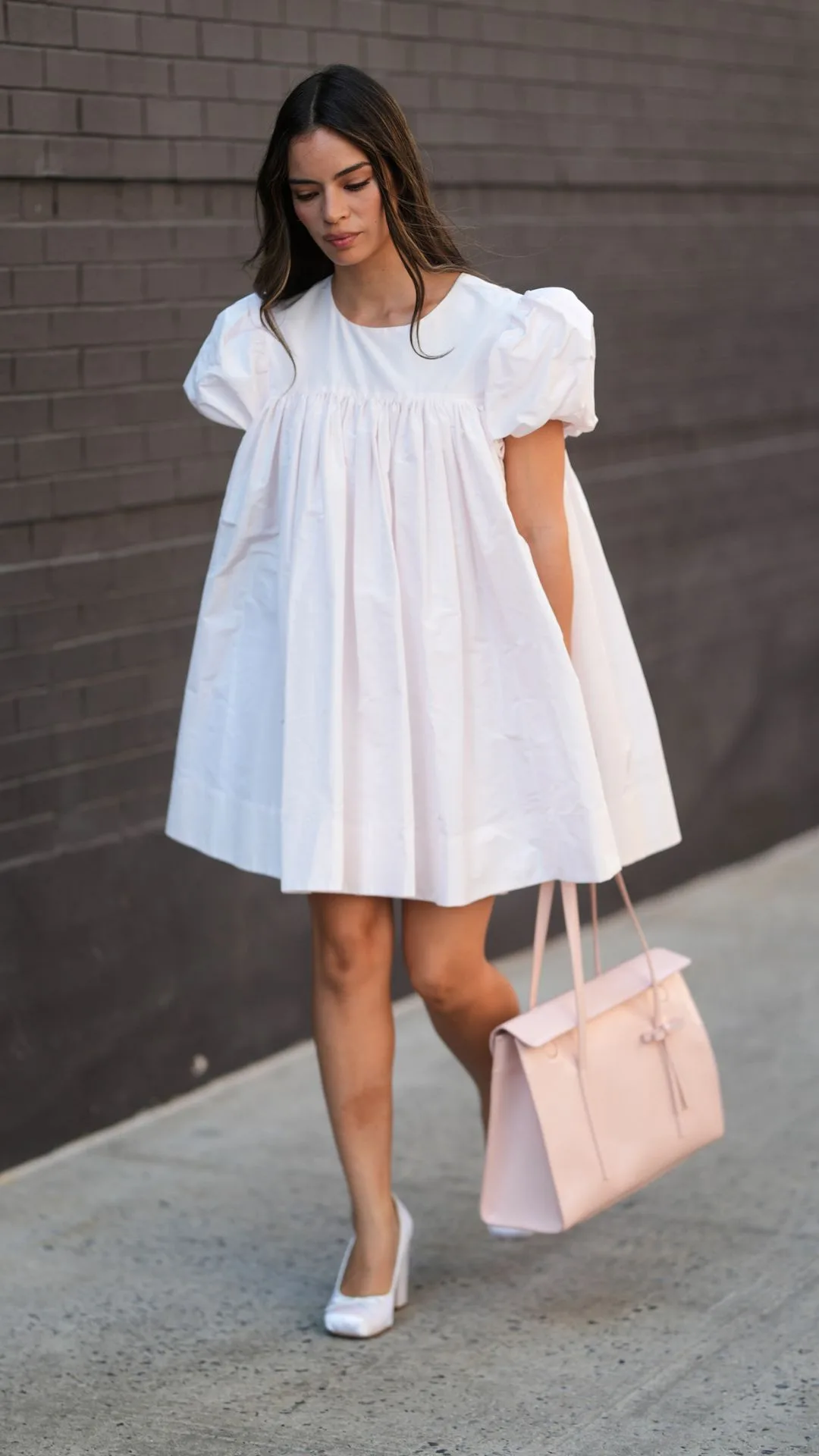 Guest at NYFW wears puff sleeved white sandy liang dress 