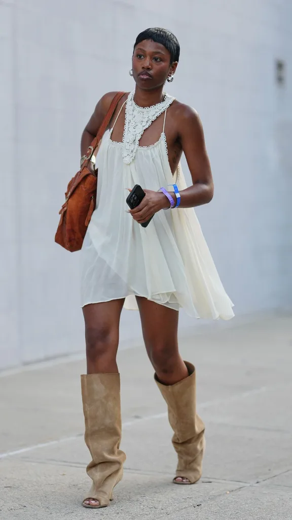 a guest wears a short white flowy dress with toe boots