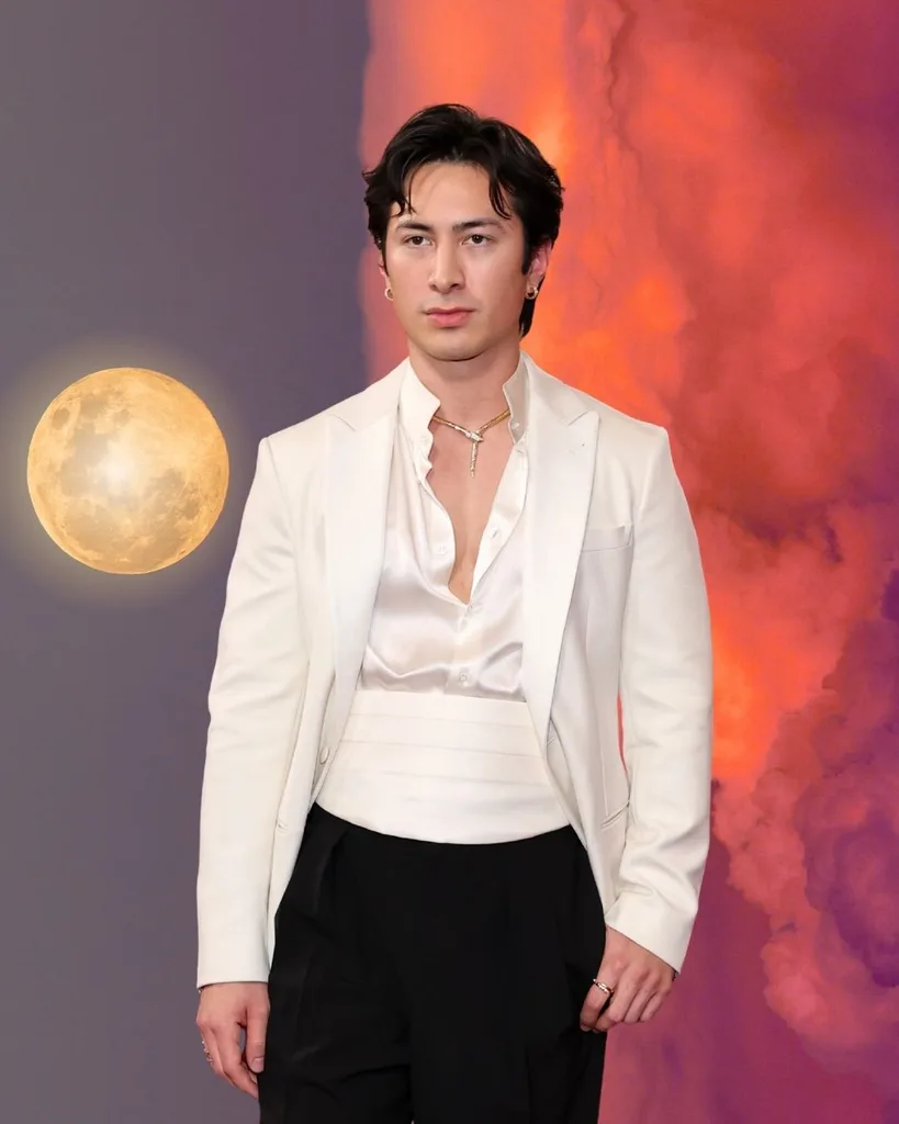 Hudson williams in front of a full moon rising over a sunset