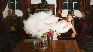 Woman in wedding dress posed on lounge