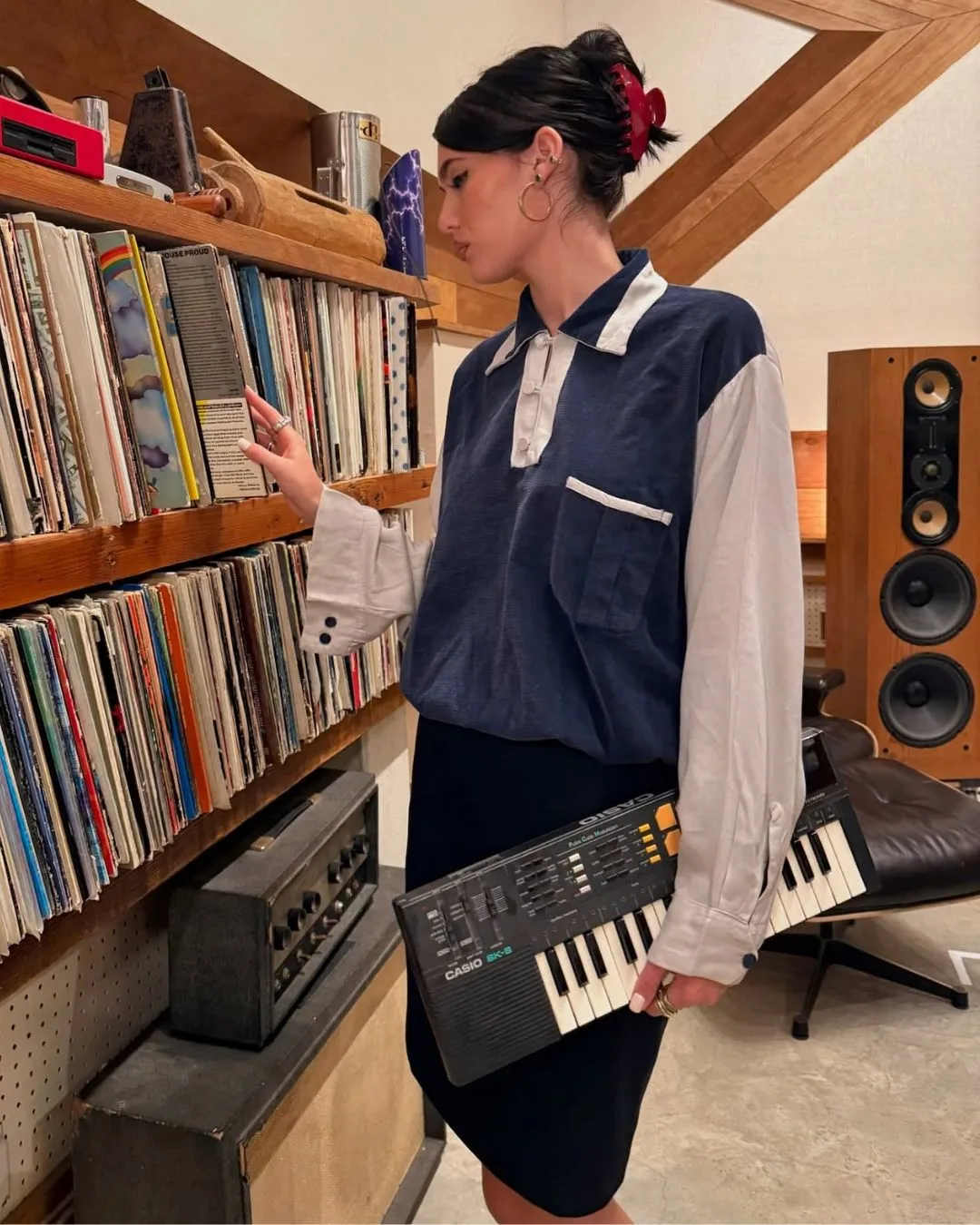 Sienna Spiro holding a keyboard flicking through records 