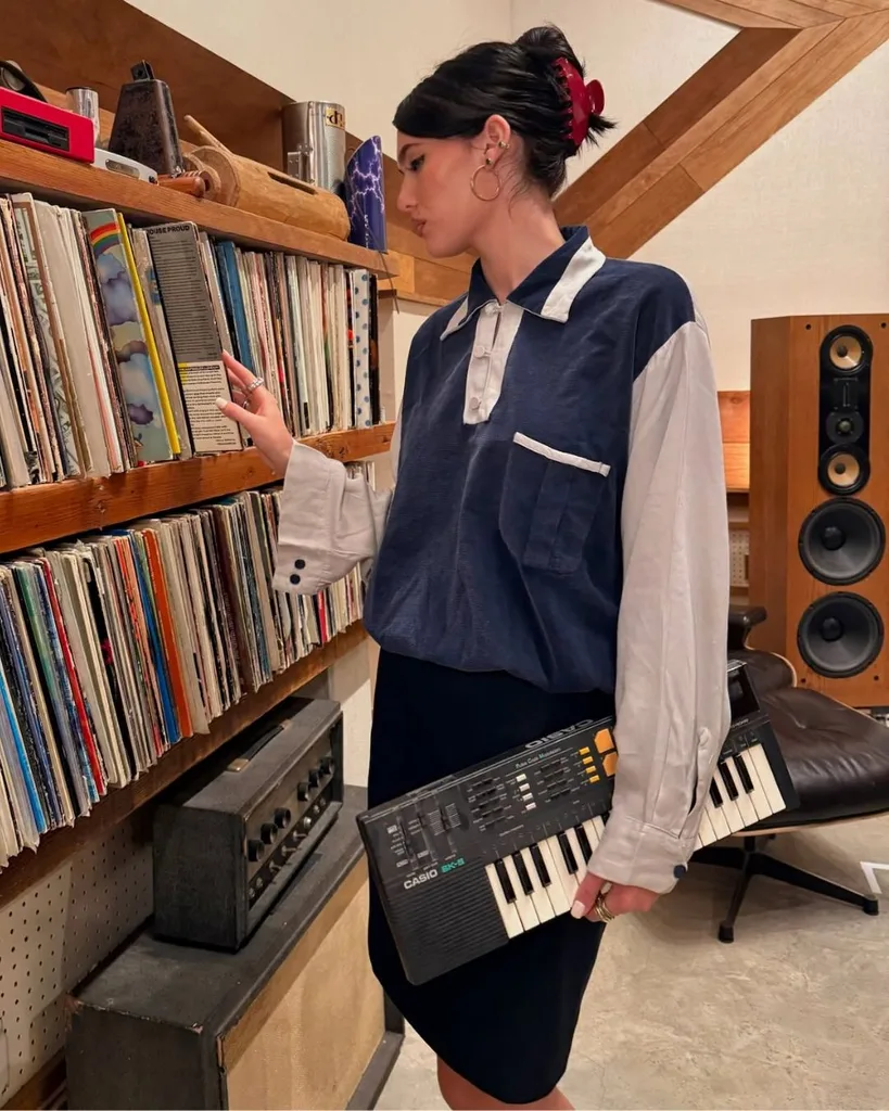 Sienna Spiro holding a keyboard flicking through records