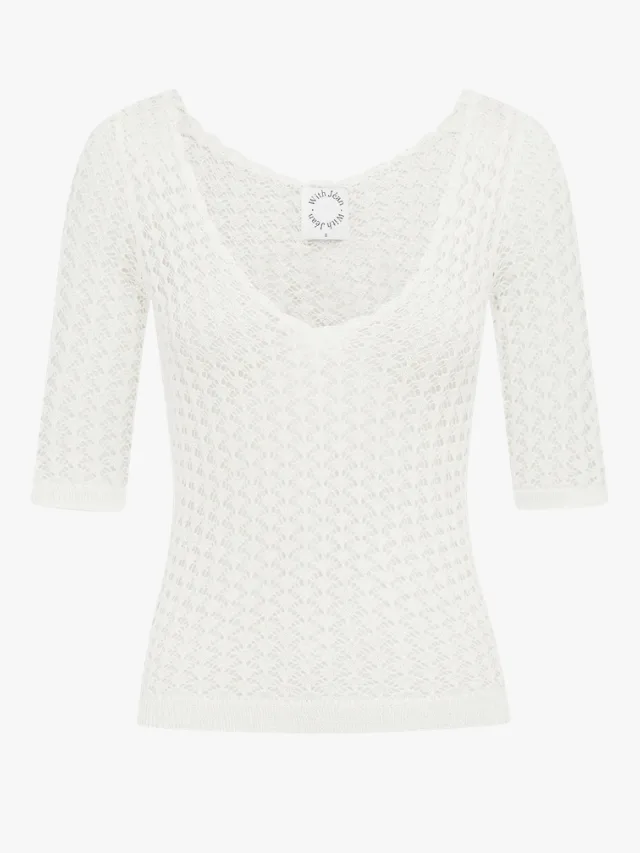 white crochet knit top with 3/4 sleeves and scoop neckline by With Jean, worn by Dua Lipa