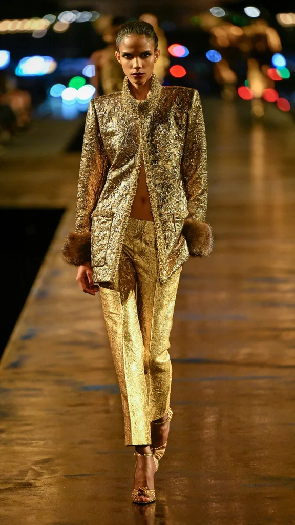 A model wearing a gold jacket and pants