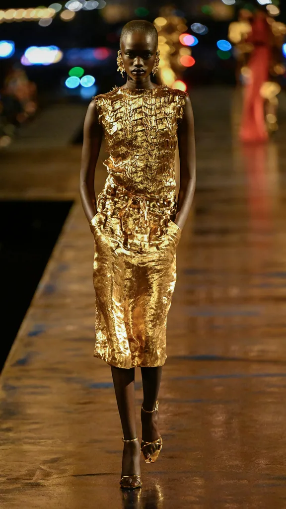 A model wearing a gold skirt and singlet set