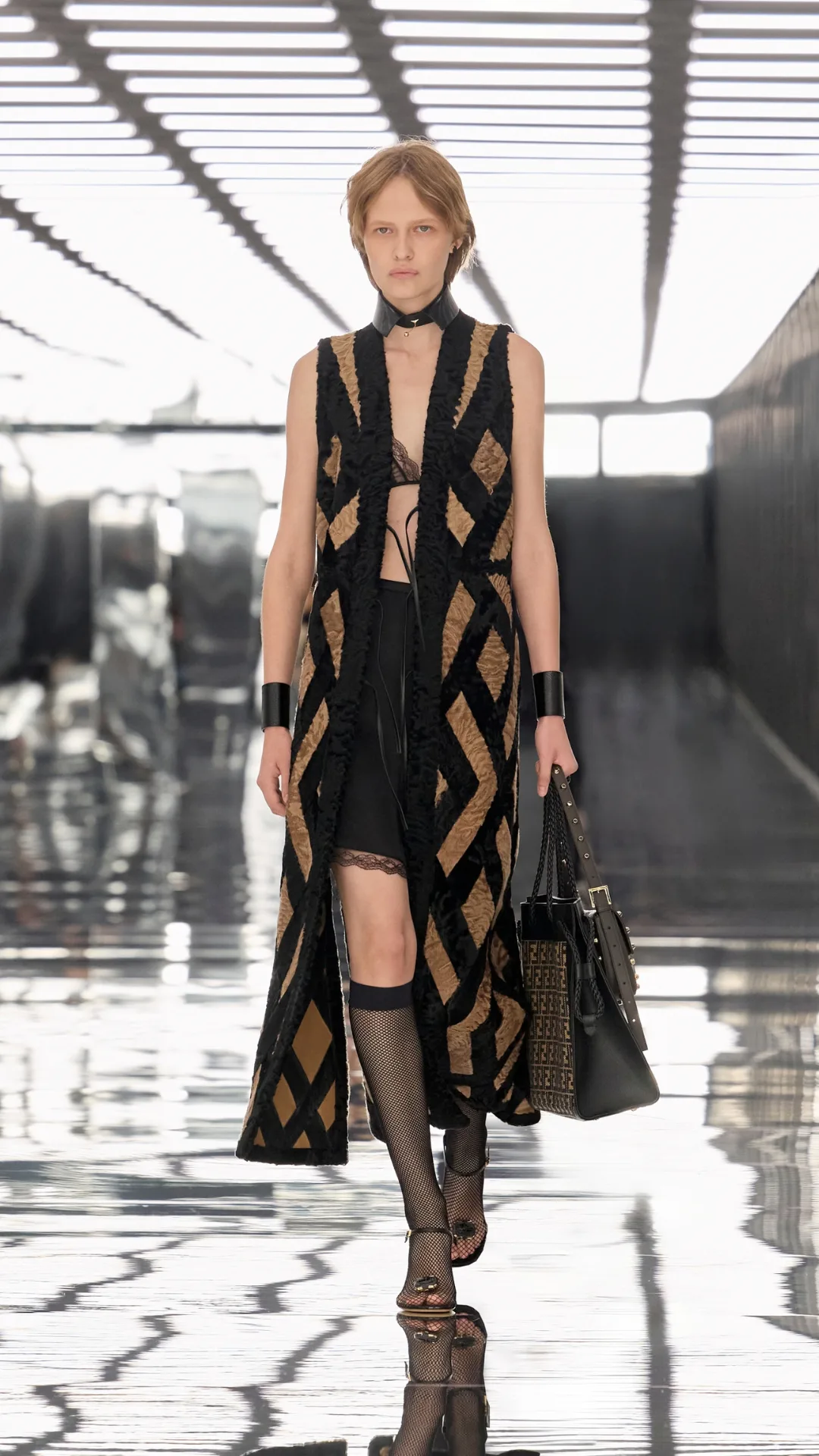 Model in an embroidered black vest with boots