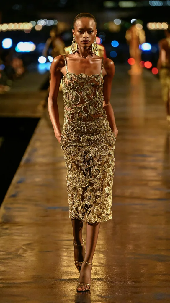 A model wearing a gold lace dress