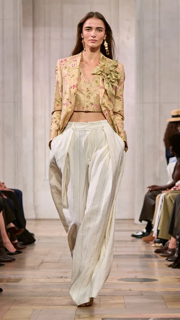 A look from the Ralph Lauren show with the model wearing a brocade floral jacket and waistcoat with white trousers.