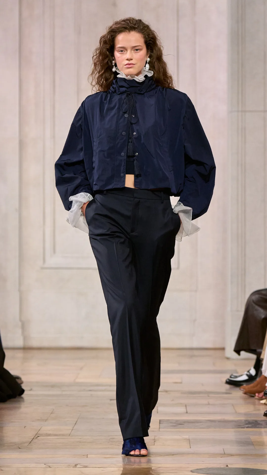 A look from the Ralph Lauren show with the model wearing a navy blue jacket and matching pants with a white blouse.
