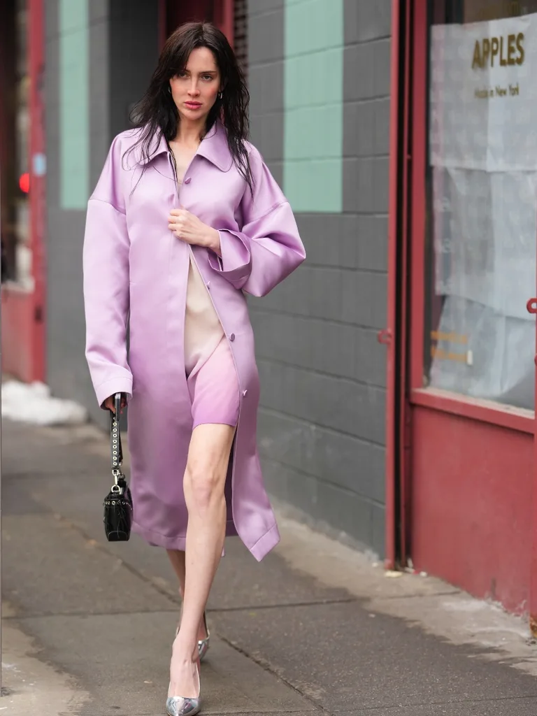Woman wears purple satin coat in New York