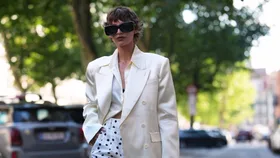 Woman wears white silk jacket and polkadot shorts at Copenhagen Fashion Week