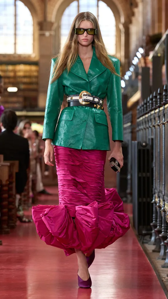 A model wearing a pink skirt and green jacket
