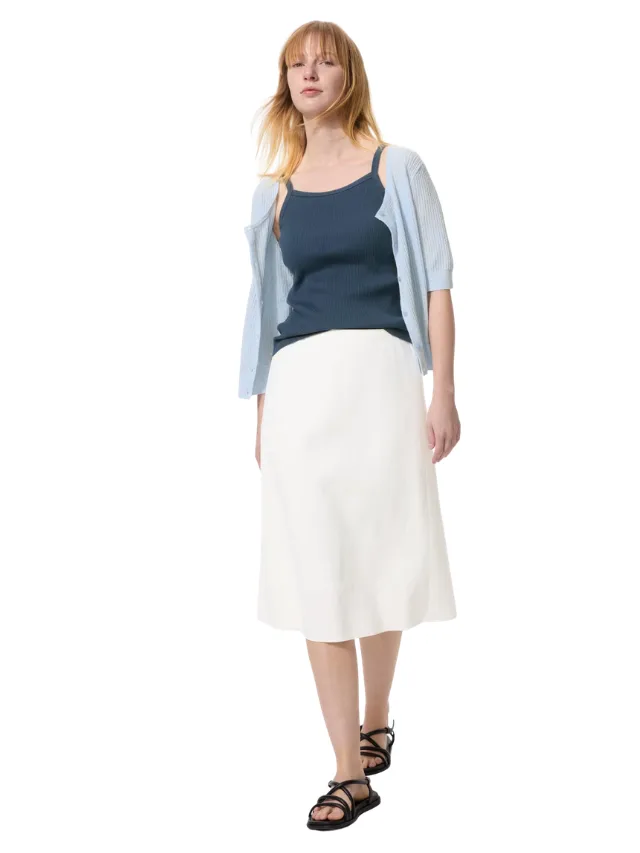 A model wearing a white skirt and blue top