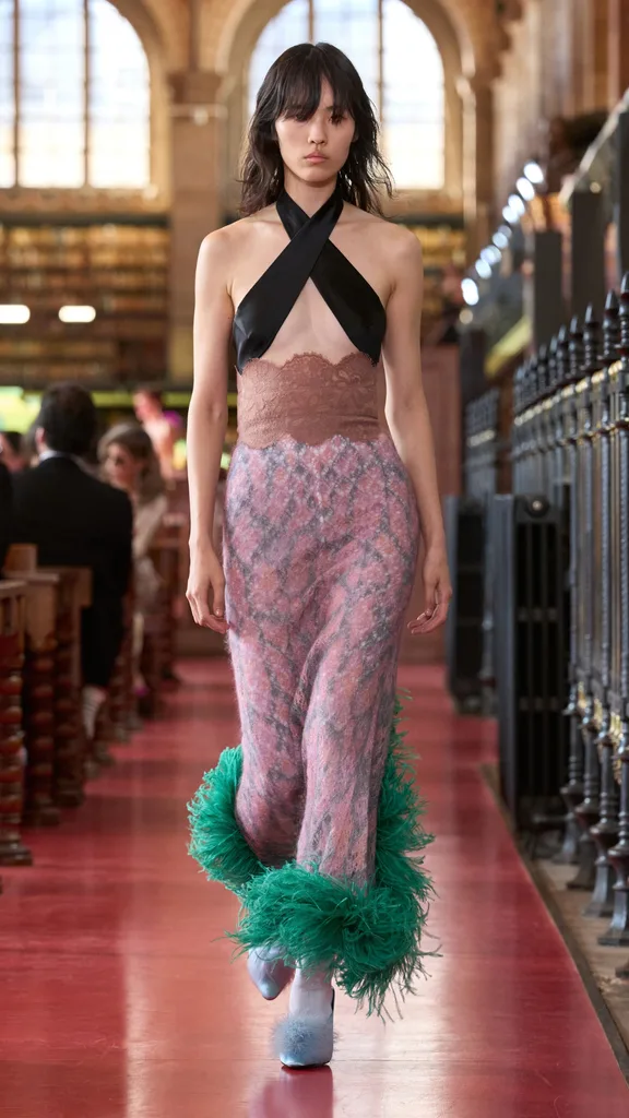 A model wearing a pink skirt and black bralette