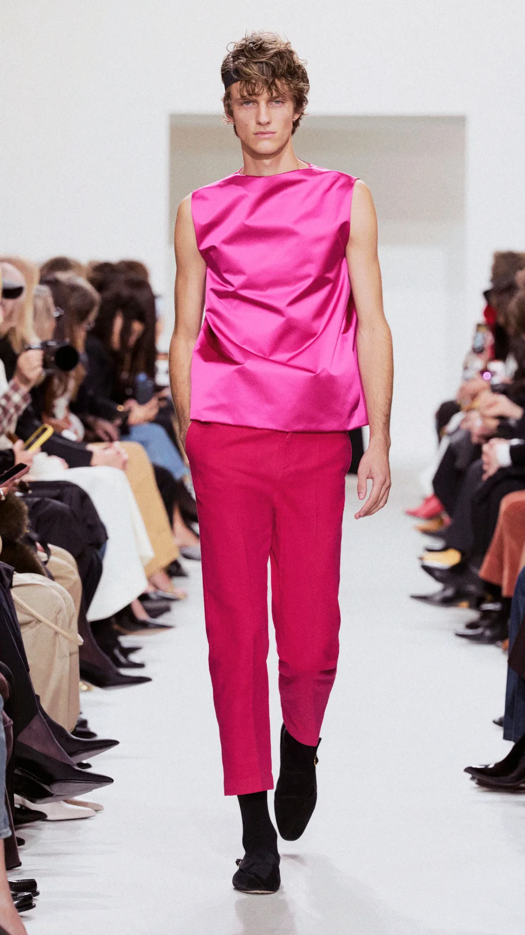 A model wearing a pink top and red pants