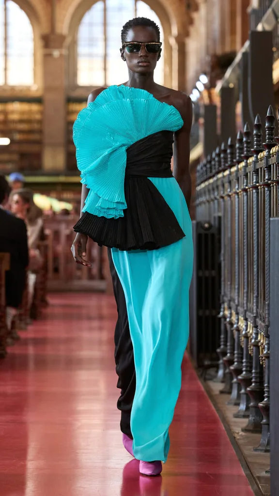 A model wearing an aqua and black gown