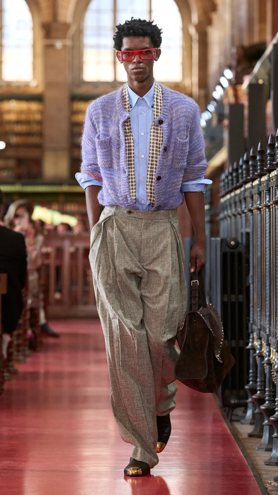 A model wearing beige pants and a purple shirt