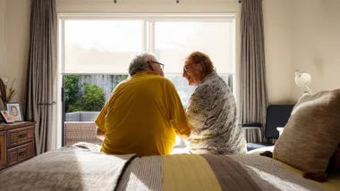 older couple sitting on a bed