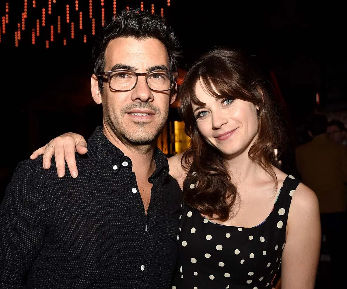 Couple posing closely at an event, with the woman wearing a polka dot dress.