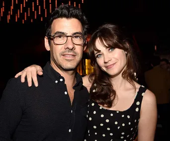 Couple posing closely at an event, with the woman wearing a polka dot dress.