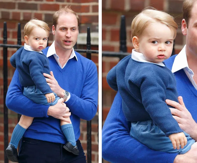 Man in blue sweater holding a child in a matching outfit, with a brick wall in the background.