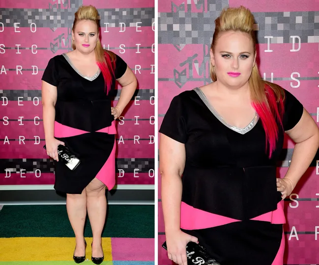 Blonde woman with pink hair highlights in a black and pink dress at MTV Video Music Awards, holding a sparkling clutch.