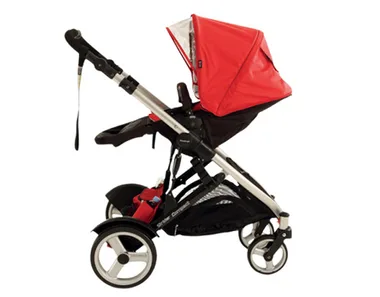 Red stroller with a silver frame, side view, featuring four wheels and an adjustable canopy.