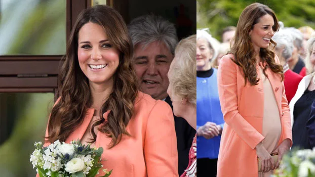 Pregnant woman in a peach coat holding flowers, smiling among a group of people.