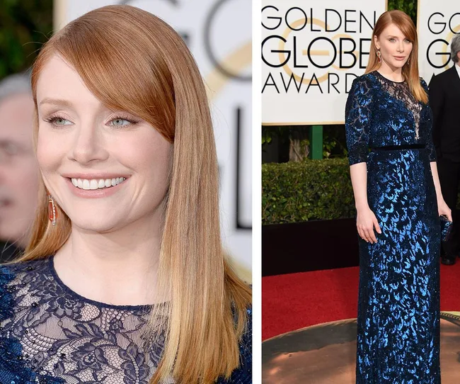 Red-haired woman in a blue lace gown at Golden Globe Awards, smiling and posing on the red carpet.