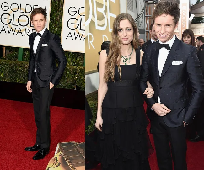 Two people in formal attire on the red carpet at the Golden Globe Awards.