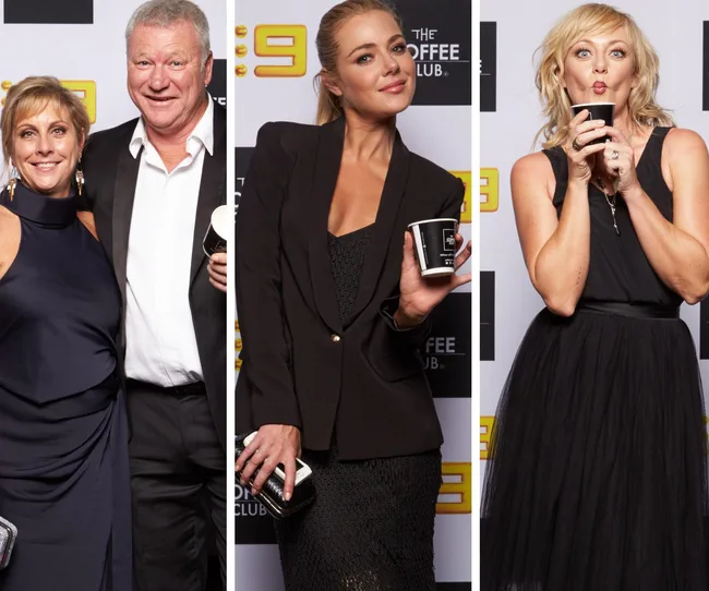 Three people posing at an event, each holding a coffee cup, on a step-and-repeat backdrop.