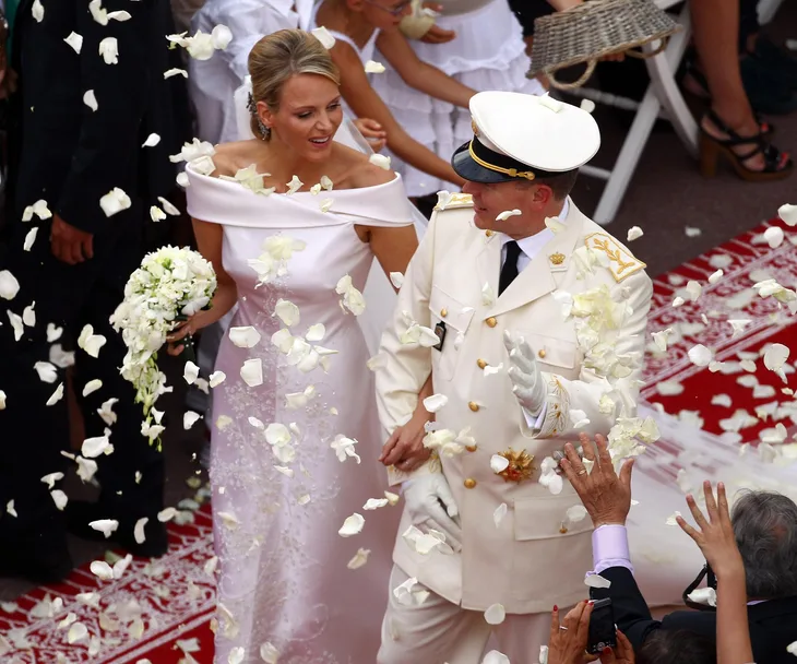 Prince Albert and Princess Charlene of Monaco during their wedding, surrounded by white rose petals.