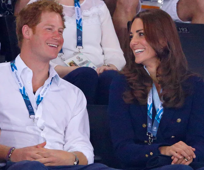 Two people smiling and seated at an event, wearing lanyards and casual attire.