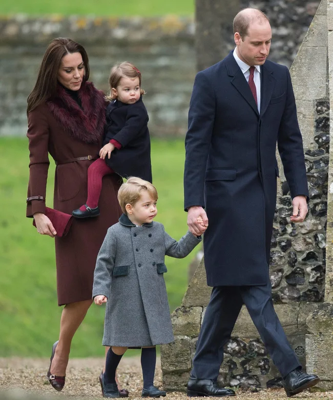 A family with two children attends a Christmas church service, dressed in winter coats, walking hand in hand.