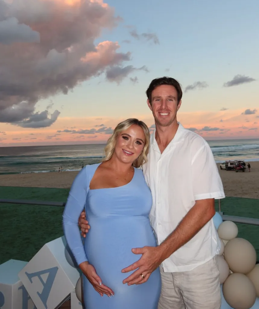 Jenny wears a baby blue dress with Dylan holding her growing belly. 