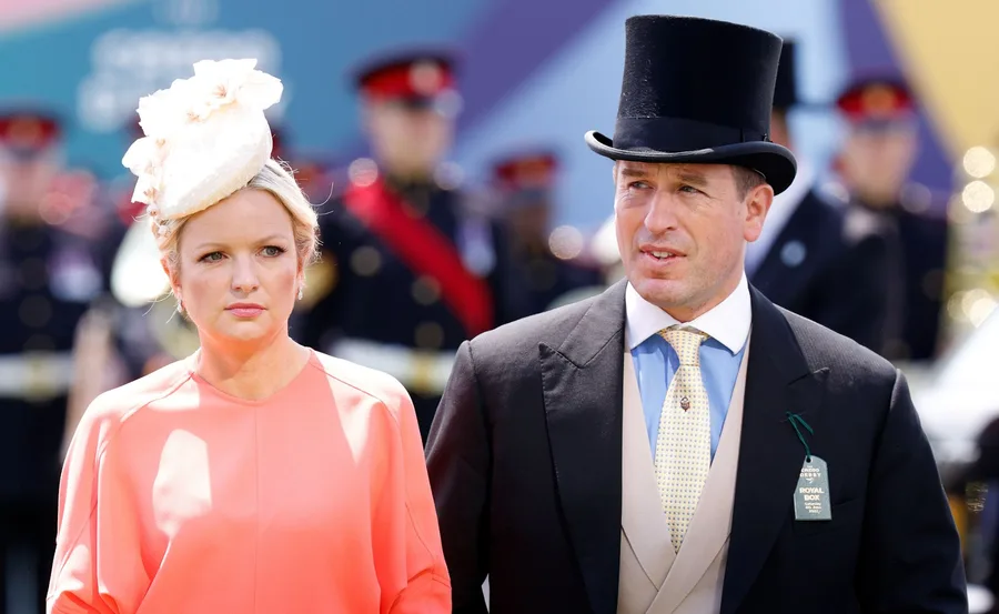 A man in a top hat and a woman in a peach outfit with a fascinator at a formal event.