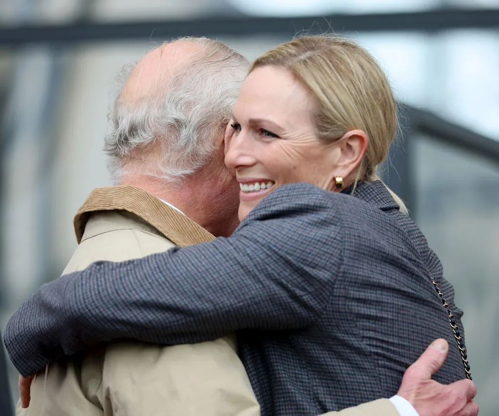 King Charles and niece Zara Tindall smiling and hugging.