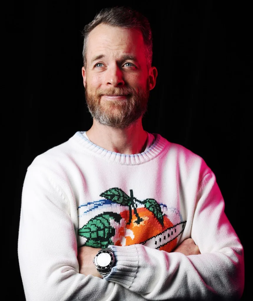 Hamish Blake crossing his arms looking away from camera.