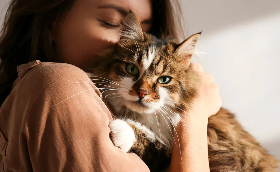 woman snuggling cute cat