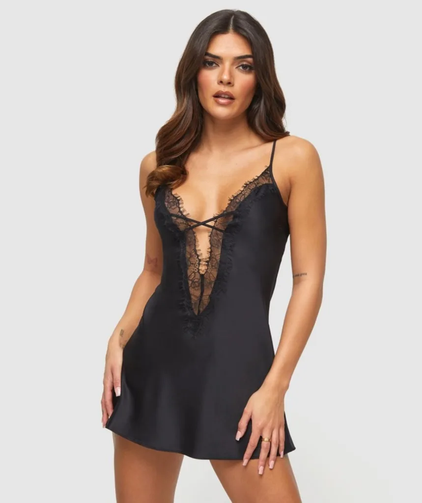 Brunette woman wearing black lace slip with criss cross detail at bust