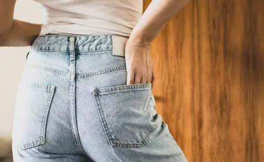 high waisted jeans in a light blue flatter the woman's backside